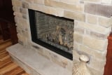 Stone wall wood fired fireplace