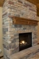 Stone wall fireplace with floating mantle